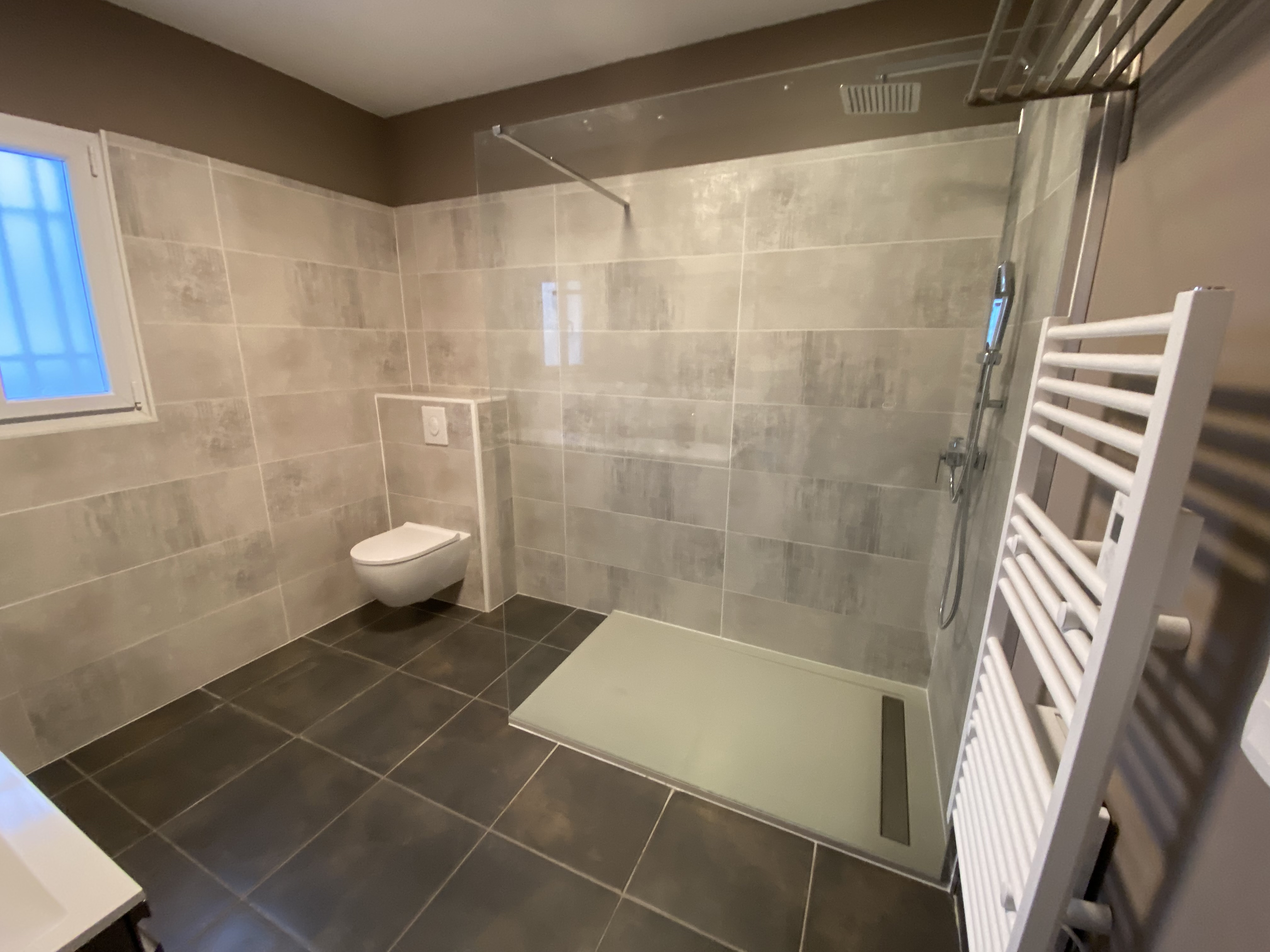 Salle de bain rénovée vue d'ensemble carrelage plomberie